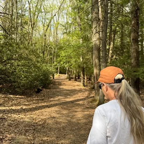 lady walking through the forest and campground at rustic acres rv resort and campground